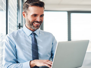 Anzugtraeger-Laptop-laecheln-255623642-AS-baranq