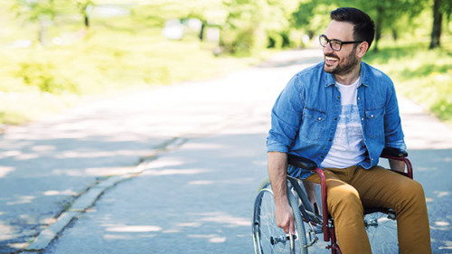 Mann-lachend-Rollstuhl-218188481-AS--Jelena