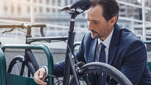 Anzugtraeger-sperrt-Fahrrad-ab-168407964-AS-dima-sidelnikov