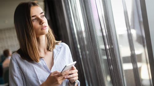 Frau-Smartphone-Fenster-296057191-AS-nd3000