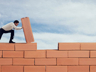 Anzugtraeger-baut-Mauer-262410749-AS-alphaspirit