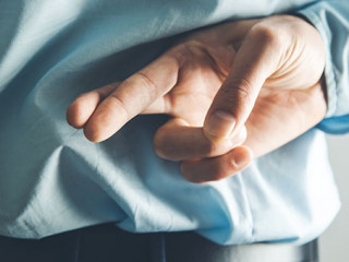 Anzugtraeger-Finger-gekreuzt-241497426-AS-Tiko