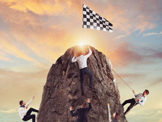 Anzugtraeger-erklettern-Berg-281129915-AS-alphaspirit