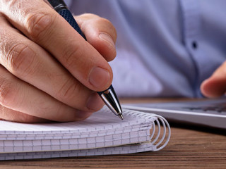 Mann-Notizblock-Laptop-222403991-FO-Andrey-Popov