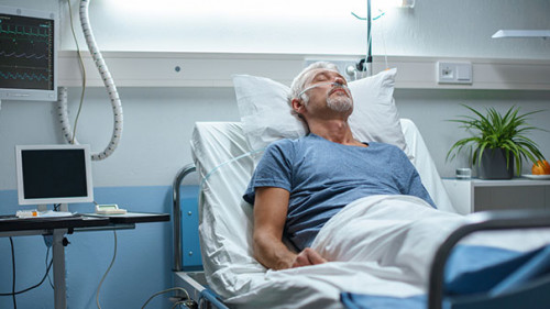 Mann-Krankenbett-224040273-AS-Gorodenkoff