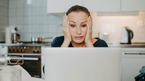 Frau-verzweifelt-vor-Laptop-337306464-AS-Michaela-Begsteiger