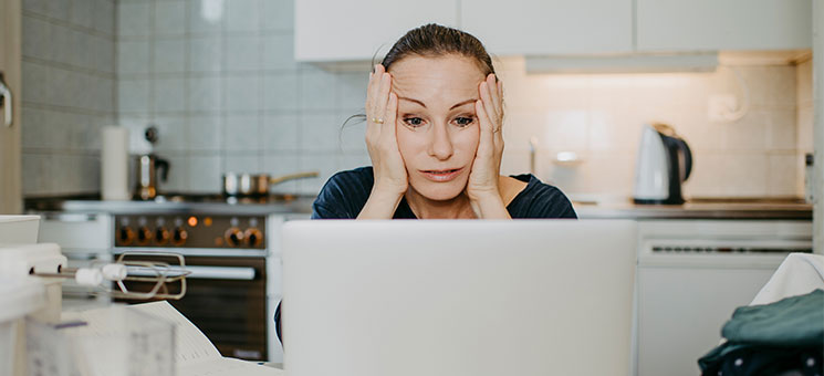 Frau-verzweifelt-vor-Laptop-337306464-AS-Michaela-Begsteiger