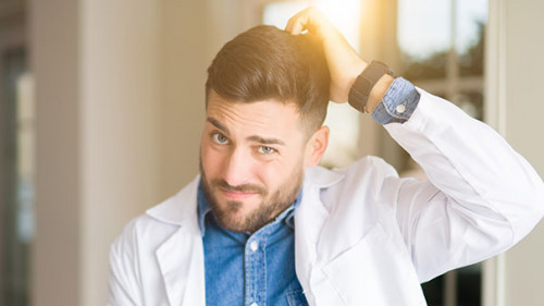 Arzt-kratzt-sich-an-Kopf-286407631-AS-Krakenimages-com