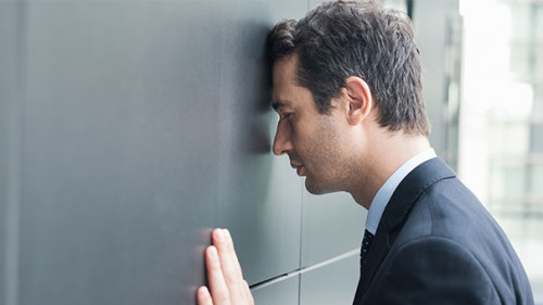 Anzugtraeger-Kopf-an-Wand-220627253-AS-Paolese