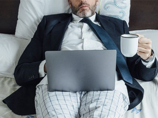 Anzugtraeger-Bett-Laptop-334547923-AS-karrastock