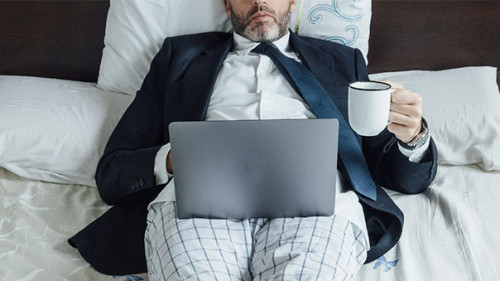 Anzugtraeger-Bett-Laptop-334547923-AS-karrastock