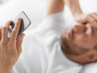 Mann-Bett-Smartphone-Kopfschmerzen-256398955-AS-Syda-Productions