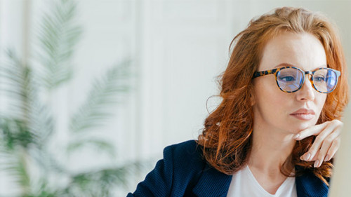 Anzugtraegerin-vor-Laptop-258949749-AS-VK-Studio