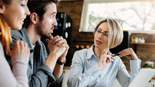 Paar-Anzugtraegerin-Beratung-330048552-AS-Drazen