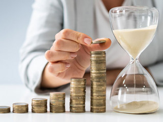 Anzugtraegerin-Muenzturm-Sanduhr-309514485-AS-Andrey-Popov