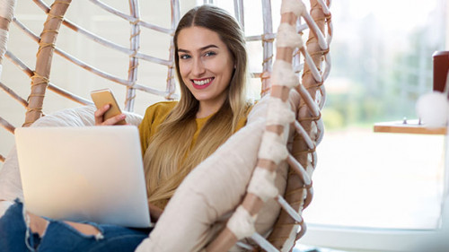 Frau-Laptop-Smartphone-daheim-256470851-AS-pikselstock