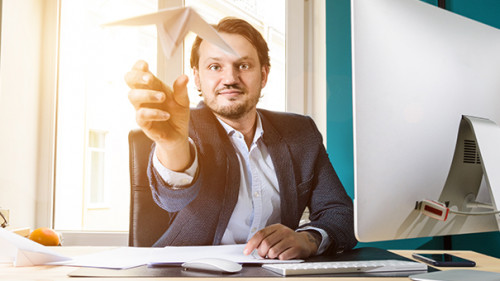 Anzugtraeger-wirft-Papierflieger-152699516-AS-Sergey-Peterman