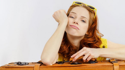 Frau-Koffer-gelangweilt-158092671-AS-contrastwerkstatt