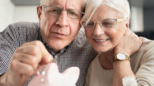 Senioren-paar-Sparschwein-260344496-AS-Proxima-Studio