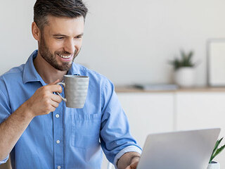 Mann-Laptop-Laecheln-372228175-AS-Prostock-studio