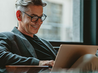 Anzugtraeger-Laptop-Laecheln-333318146-AS-Jacob-Lund