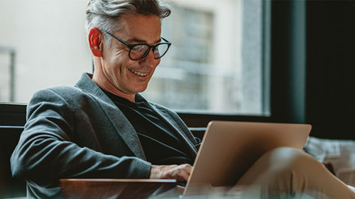 Anzugtraeger-Laptop-Laecheln-333318146-AS-Jacob-Lund