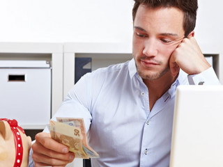 Mann-Geldscheine-Sparschwein-39197943-AS-Robert-Kneschke