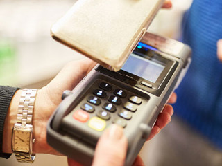 Frau-bezahlt-per-Smartphone-291888977-AS-Robert-Kneschke