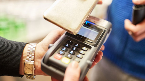 Frau-bezahlt-per-Smartphone-291888977-AS-Robert-Kneschke