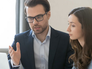 Anzugtraeger-Frau-Laptop-Beratung-254473408-AS-fizkes