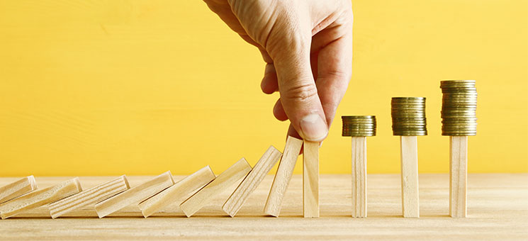 Hand-Dominos-Muenzstapel-215599630-AS-tomertu