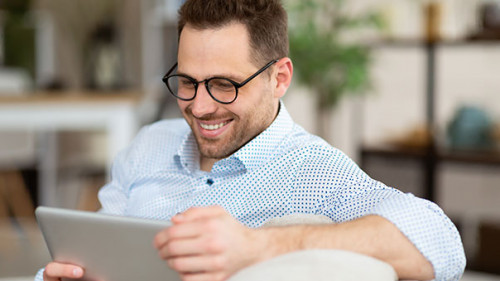Mann-Tablet-Laecheln-360458841-AS--Prostock-studio