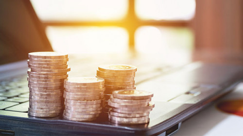 Muenzstapel-auf-Laptop-191056800-AS-krisana