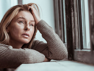 Frau-Fenster-traurig-253059493-AS-zinkevych