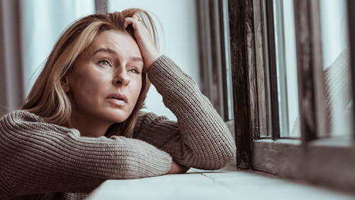 Frau-Fenster-traurig-253059493-AS-zinkevych