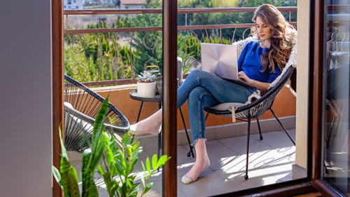 Frau-Balkon-Laptop-339526092-AS-Gabi-Moisa