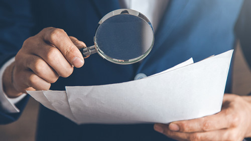 Anzugtraeger-Lupe-Papier-278805688-AS-Tiko