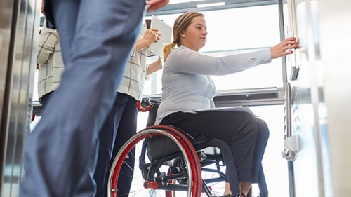 Anzugtraeger-Rollstuhl-Aufzug-310173813-AS-Robert-Kneschke