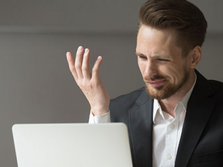 Anzugtraeger-kritisch-Laptop-203793694-AS-fizkes