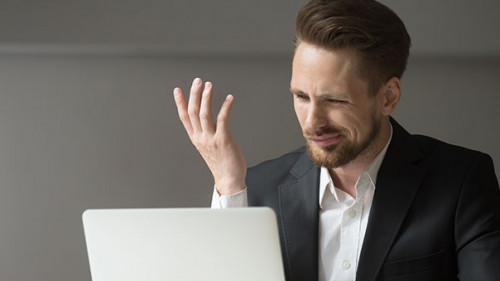 Anzugtraeger-kritisch-Laptop-203793694-AS-fizkes