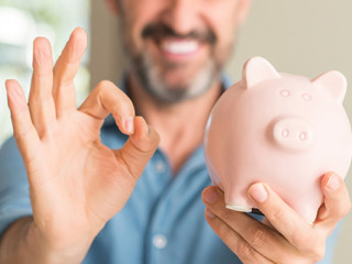 Mann-laecheln-Sparschwein214703124-AS-Krakenimages-com