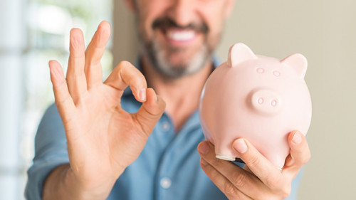 Mann-laecheln-Sparschwein214703124-AS-Krakenimages-com