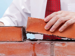 Anzugtraeger-baut-Mauer-236913934-AS-jivimages