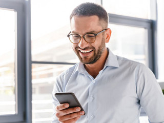 Anzugtraeger-Smartphone-Laecheln-207739738-AS-Drobot-Dean