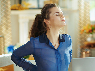 Frau-Rueckenprobleme-Homeoffice-332540746-AS-Alliance