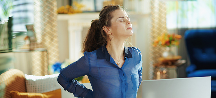 Frau-Rueckenprobleme-Homeoffice-332540746-AS-Alliance