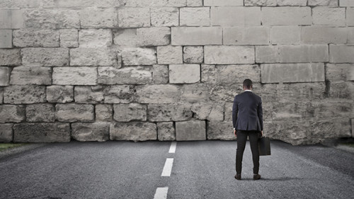 Anzugtraeger-vor-Mauer-157072263-AS-olly