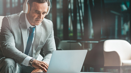 Anzugtraeger-Laptop-Kopfhoerer-284509719-AS-Adamov