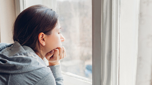 Frau-Fesnter-traurig-333936595-AS-maryviolet