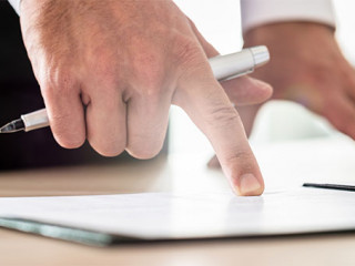 Hand-zeigt-auf-Papier-233885315-AS-Gajus